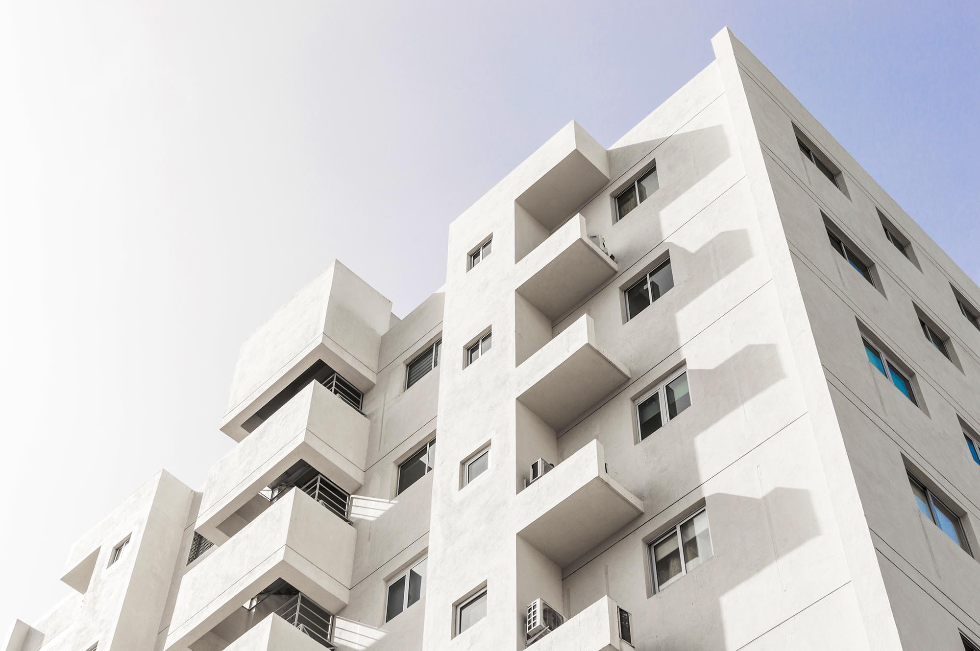 Inquadratura dal basso-facciata-bianco-edificio-moderno-blu-cielo-chiaro